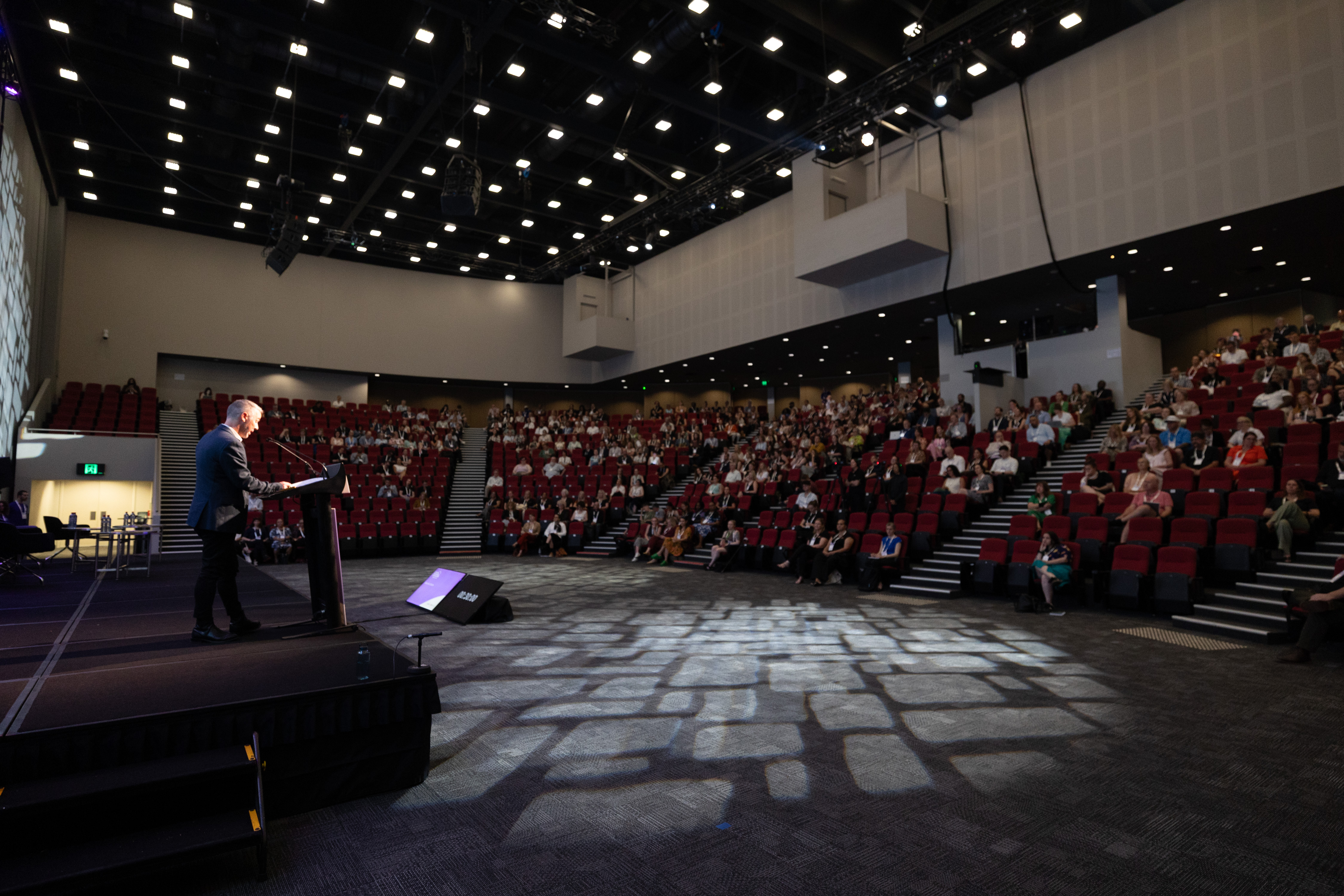 Dr Tom Alves addressing crowd for closing session at Australian Homelessness Conference 2026