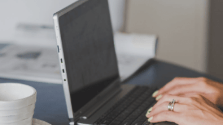Woman sitting at desk typing on laptop