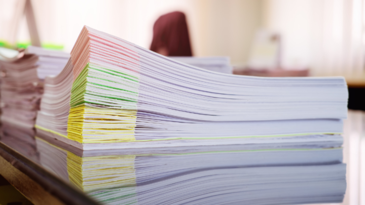 Stack of papers with various coloured sticky notes neatly marking the corners