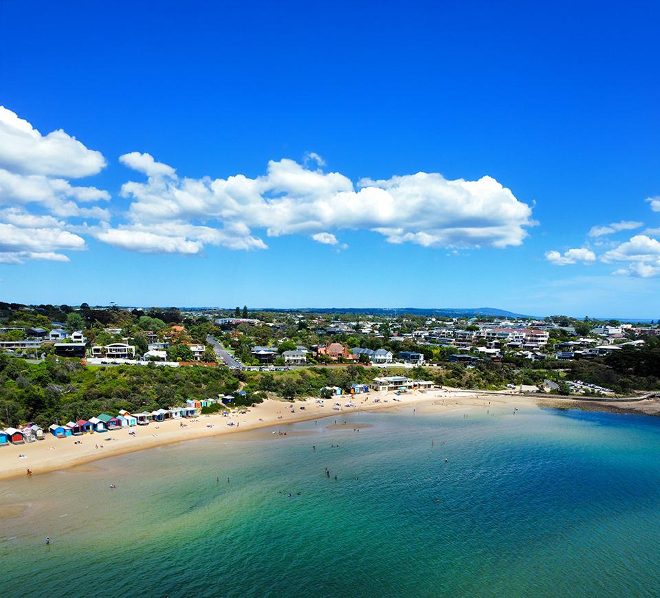 Aerial view of an Australian beach with blue skies and water
