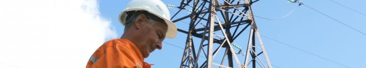 construction worker with power pylon behind him