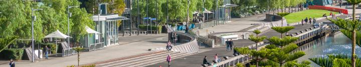 Waterfront with walking people, water and boardwalk