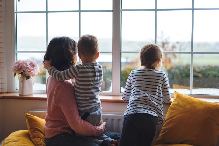 Women with kids looking out window