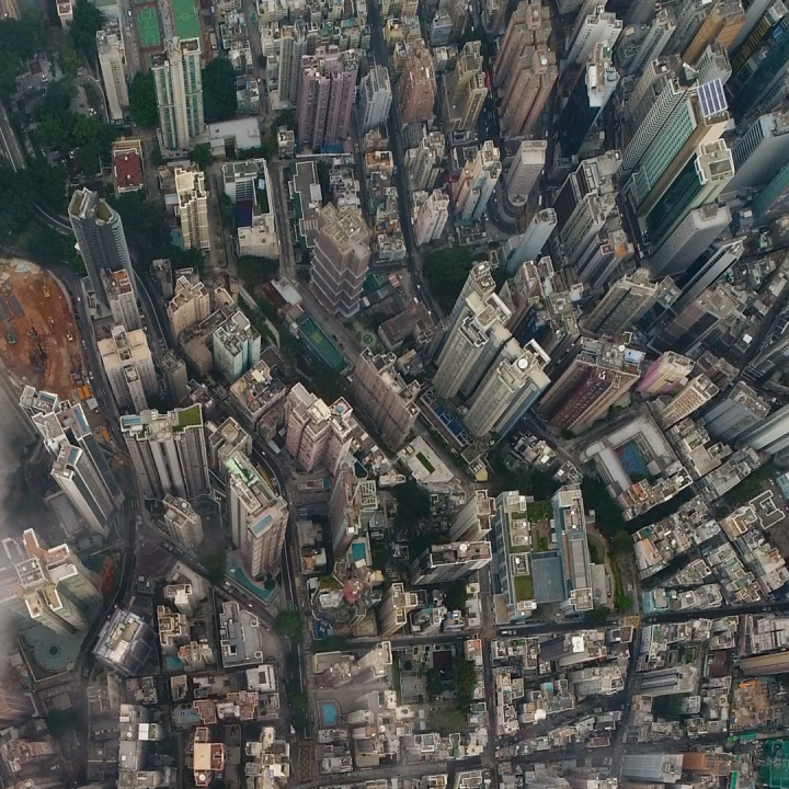 Birds eye view of densely packed city skyline with light clouds