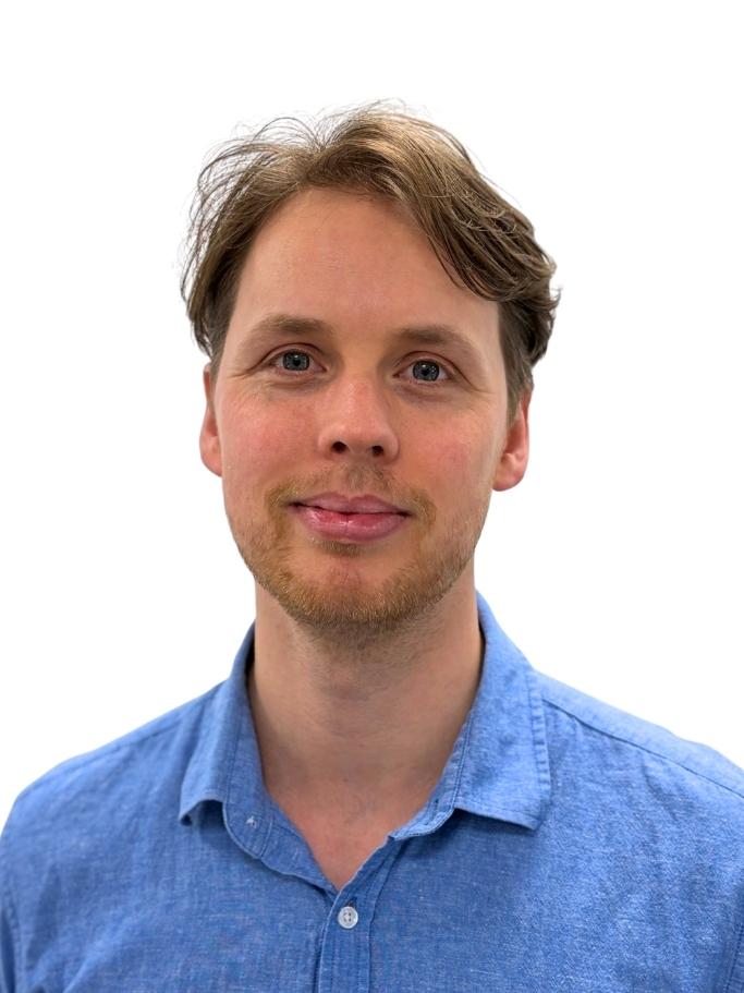 Headshot of Ged Cann. He has light brown hair and is wearing a collared blue shirt.