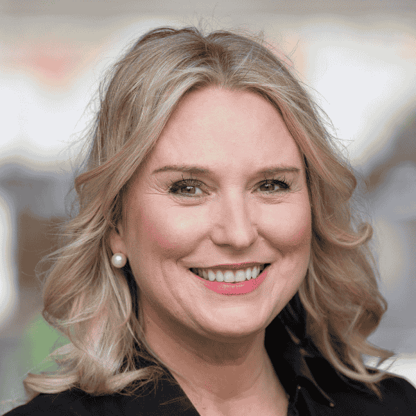 Headshot of Shelter WA CEO Kath Snell. She has blond wavy hair and is smiling at the camera.