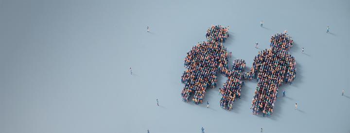 Aerial view of a plain blue background, with 2 larger people and one smaller child depicted by groups of people standing in organised shapes