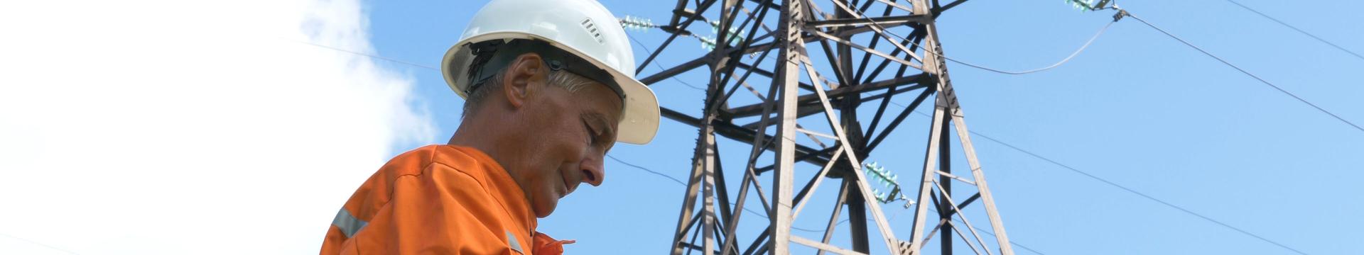 construction worker with power pylon behind him