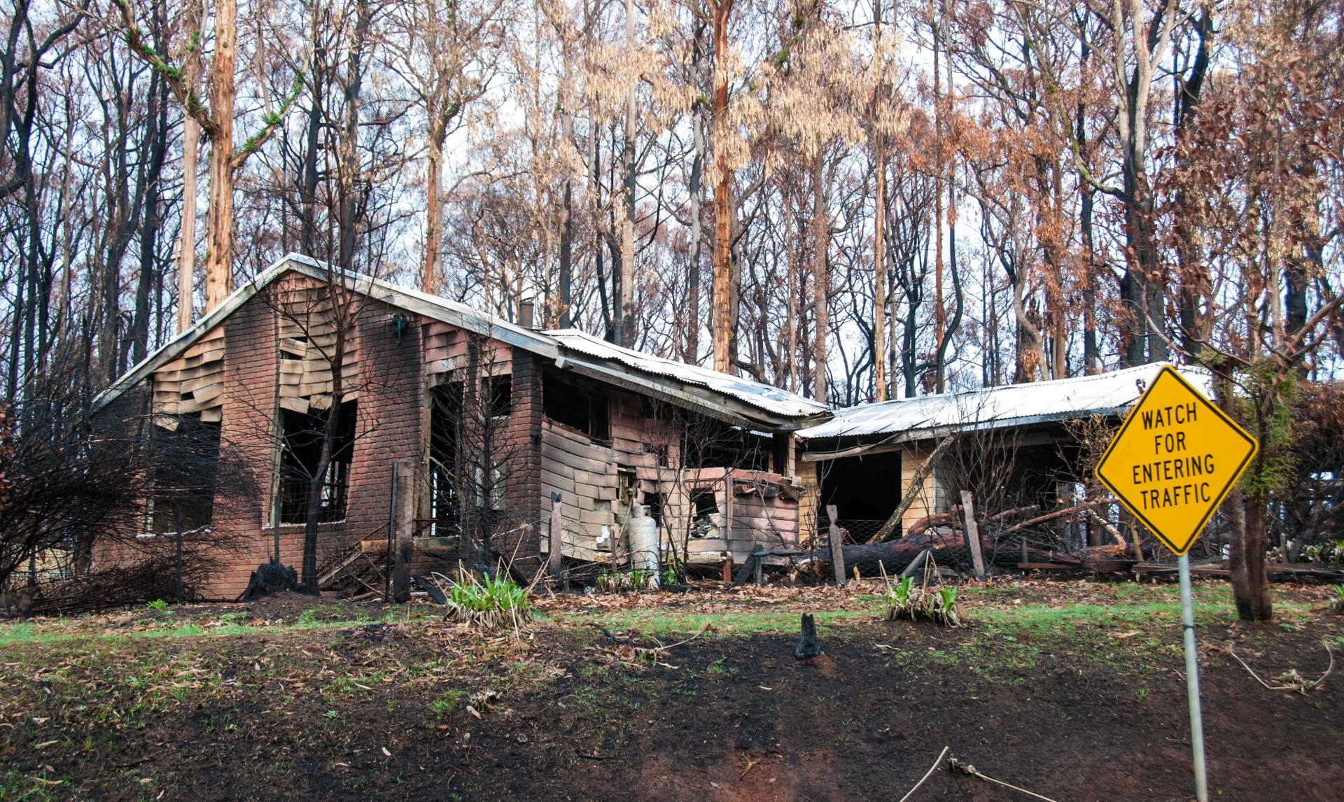 Image for AHURI Final Report 444, depicting a house and the surrounding woodlands severely damaged by bushfires