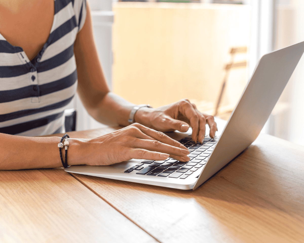 Woman sitting at a table working on a laptop