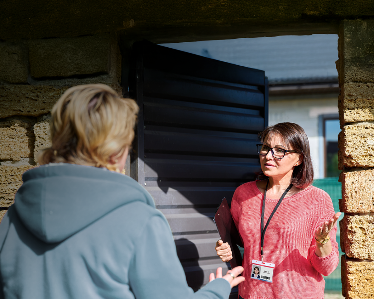 Frontline housing worker speaking with client outside