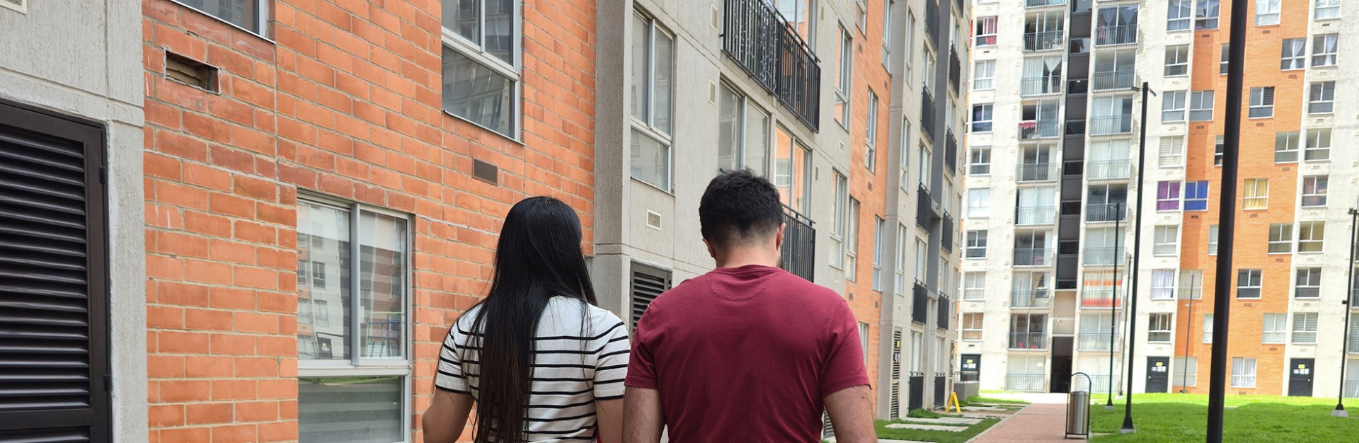 Two people walking through neighbourhood of apartment blocks