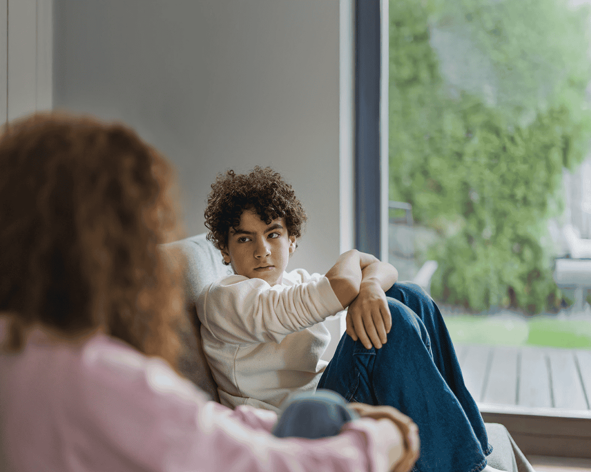 Parent and child sitting on a couch speaking